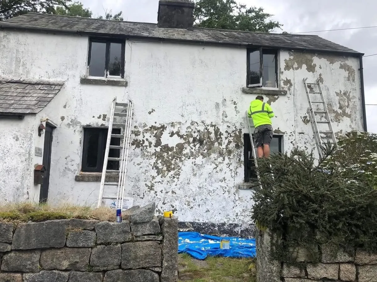 Cottage with blown, flaking render before repair in Great Torrington